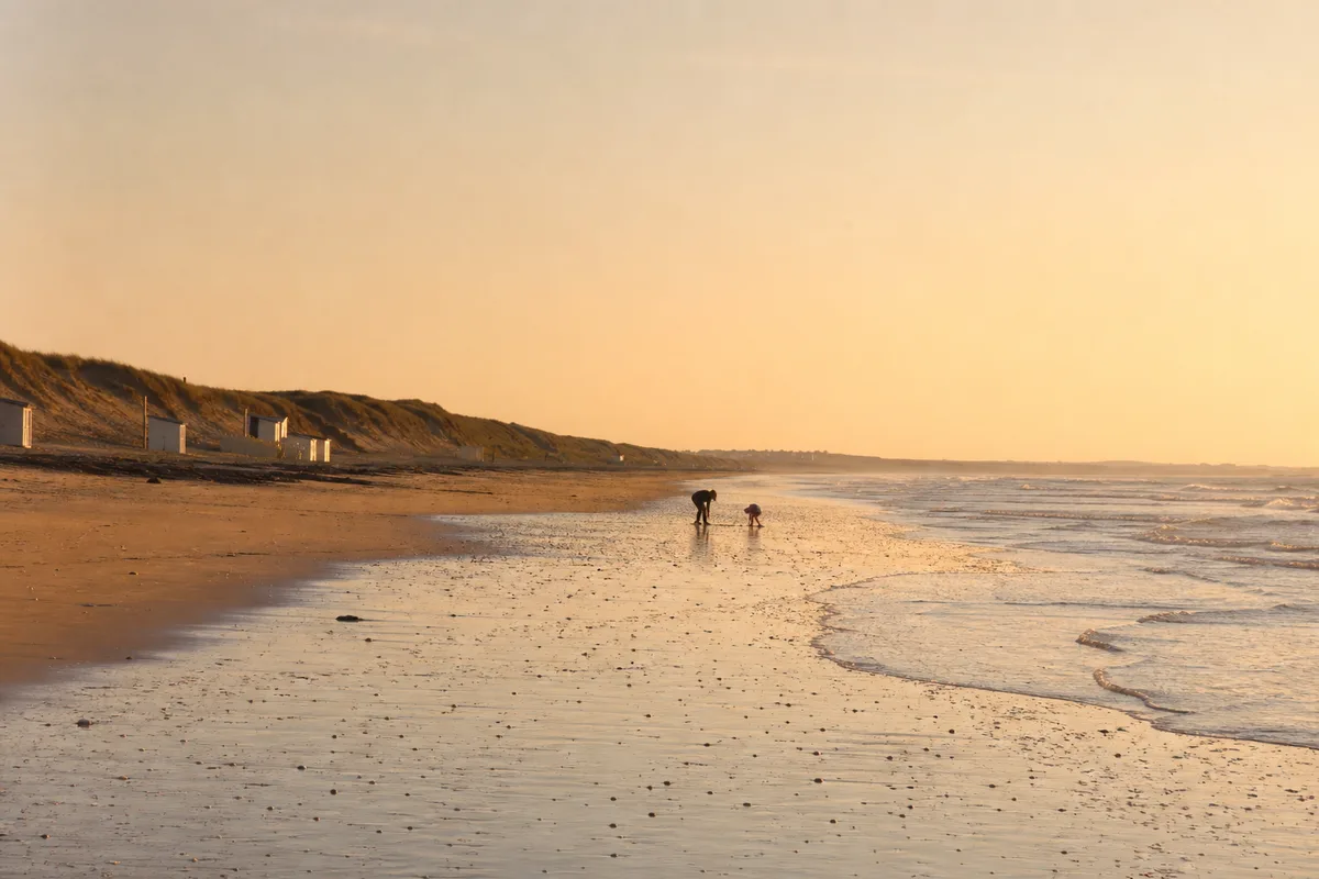 Plage française presque déserte en arrière-saison sous une lumière douce